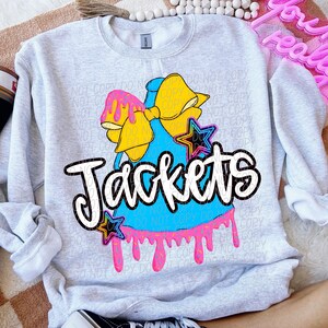 Peut inclure: Un sweat-shirt gris avec un motif bleu, rose et jaune d'un nœud, d'étoiles et du mot "Jackets".