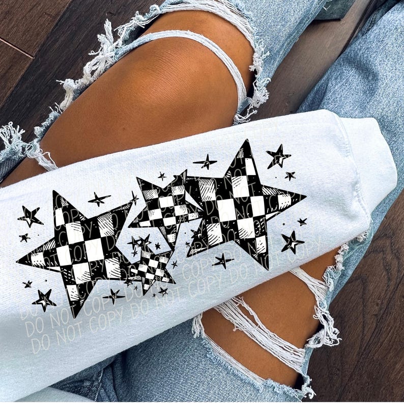 Peut inclure: Un sweat-shirt blanc avec un motif de trois &eacute;toiles &agrave; damiers noirs et blancs. Les &eacute;toiles sont soulign&eacute;es de noir et ont de petites &eacute;toiles noires autour d'elles.