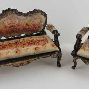 May include: A miniature set of a floral patterned couch and armchair with ornate wooden frames.