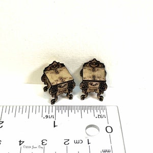 Pode incluir: Duas mesas de apoio de madeira em miniatura com entalhes intrincados e um acabamento marrom desgastado. As mesas medem aproximadamente 2,5 cm de altura e são mostradas ao lado de uma régua para escala.