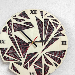 May include: A wooden clock with a geometric design featuring black and red accents. The clock face has Roman numerals and black hands.