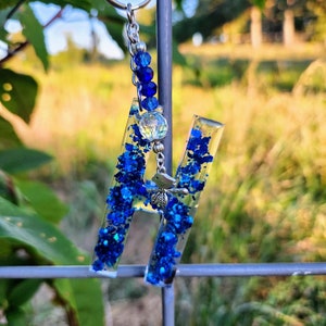 Llavero de resina azul brillante con la letra H en negrita, cuenta de cristal iridiscente, dije de pájaro, accesorio hecho a mano inspirado en la naturaleza.