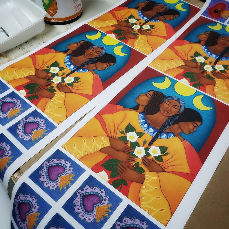 May include: Three women with long dark hair are depicted in a colorful painting. They are wearing yellow, orange, and red clothing and holding a bouquet of white flowers. The background is a blue sky with three yellow moons.