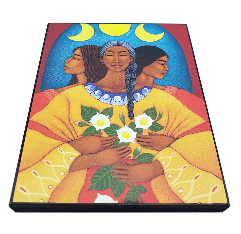 May include: A painting of three women with dark hair and brown skin, standing together and holding a bouquet of white flowers. The women are wearing yellow and red clothing, and the background is a blue and red arch with three crescent moons.