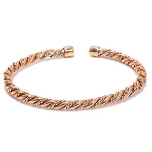 May include: A gold-toned twisted wire bangle bracelet.