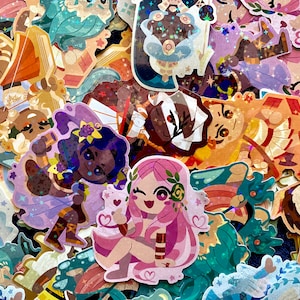 May include: A collection of colorful stickers featuring illustrations of whimsical characters. The stickers showcase a variety of designs, including figures with floral accents, stars, and other decorative elements. The color palette includes pinks, blues, and golds.