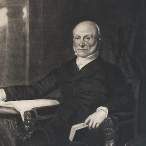 May include: A black and white portrait of a man in a suit sitting in a chair. The man is holding a book in his lap. The portrait is signed "J. Q. Adams".