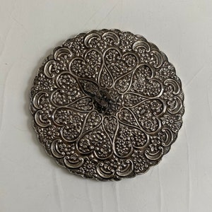 Può includere: Un vassoio circolare in argento con intricati disegni floreali e cuori in rilievo.
