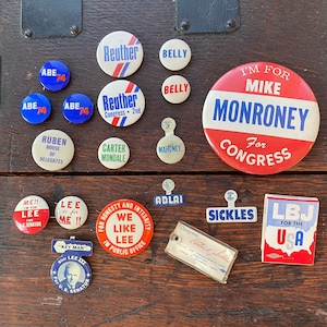 Puede incluir: Una colección de botones de campaña política vintage con varios candidatos y lemas. Los botones son rojos, blancos y azules con varios textos que incluyen "Estoy por Mike Monroney para el Congreso", "LBJ para los Estados Unidos", "Nos gusta Lee", "Reuther Congreso 2º", "Abe 74", "Carter Mondale", "Sickles", "Mahoney", "Adlai", "Ruben Cámara de Delegados", "¡Lee es para mí!", "¡Yo! para Lee Senador de los Estados Unidos", y "Belly".