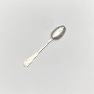K&ouml;nnte beinhalten: Ein silberner Teel&ouml;ffel mit einer abgerundeten Schale und einem schlichten, eleganten Griff. Der L&ouml;ffel hat eine Punze auf der R&uuml;ckseite des Griffs.
