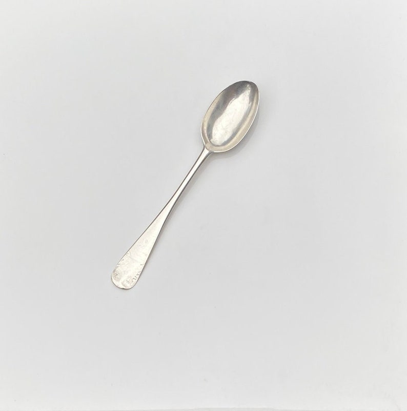 K&ouml;nnte beinhalten: Ein silberner Teel&ouml;ffel mit einer abgerundeten Schale und einem schlichten, eleganten Griff.