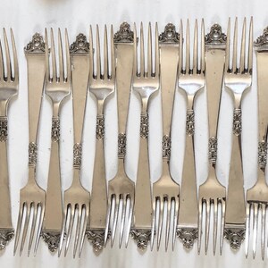 Puede incluir: Un juego de 10 tenedores de plata con mangos ornamentados. Los tenedores tienen un dise&ntilde;o cl&aacute;sico y son perfectos para cenas formales.