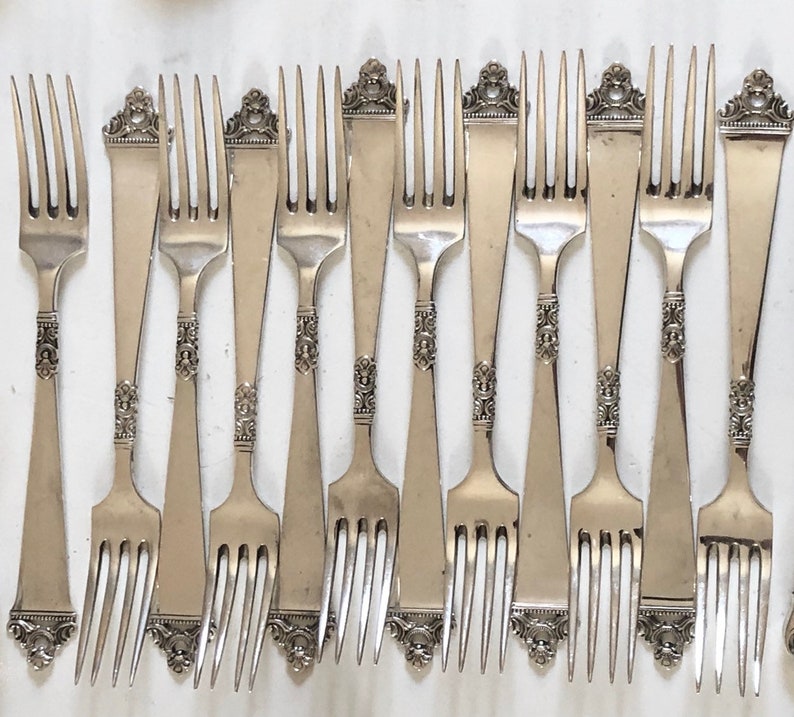 Puede incluir: Un juego de 10 tenedores de plata con mangos ornamentados. Los tenedores tienen un dise&ntilde;o cl&aacute;sico y son perfectos para cenas formales.