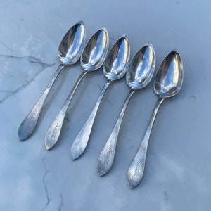 May include: Five silver spoons with ornate handles. Each spoon has the inscription "Grandmother" on the handle.