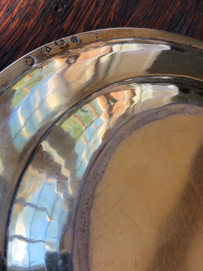 Puede incluir: Primer plano de la parte inferior de un plato de plata con una marca de fabricante que dice "S.A.O."