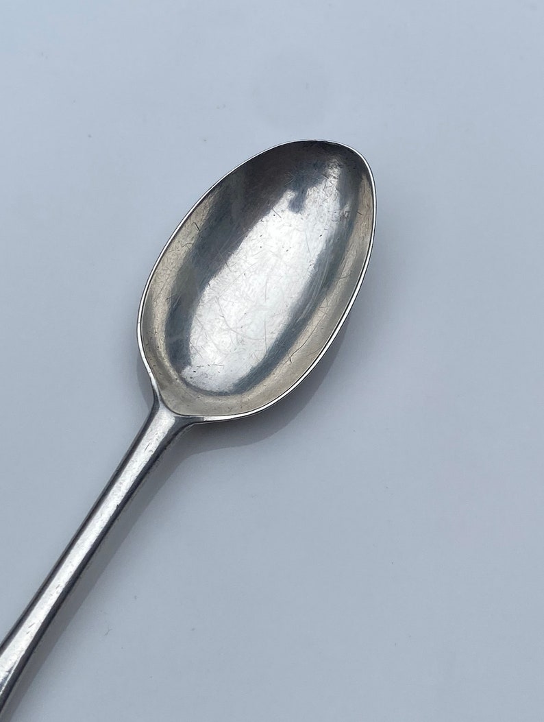 K&ouml;nnte beinhalten: Ein silberner Teel&ouml;ffel mit einer abgerundeten Schale und einem langen, schlanken Stiel.