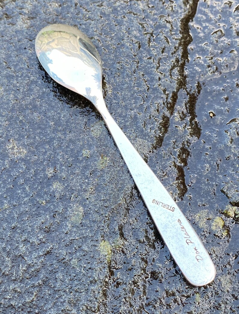 Op de afbeelding: Een zilveren theelepel met de woorden "D. Platino Sterling" gegraveerd op het handvat.