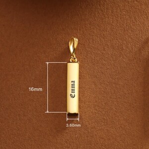 May include: A gold-colored pendant with the name "Emma" engraved on it. The pendant is rectangular, measuring 16mm in height and 3.60mm in width. It has a loop at the top for a chain.