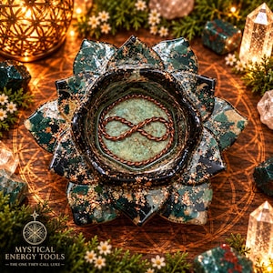 May include: A dark green lotus-shaped bowl with gold leaf accents and a glossy finish. The center of the bowl features a light green textured base with a copper wire infinity symbol embedded inside. The bowl has multiple layered petals.
