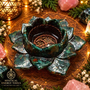 May include: A dark green and teal stone bowl shaped like a blooming lotus flower with multiple layered petals. The interior of the bowl contains a coiled copper wire element resting on a dark, textured base. The stone features natural veining.