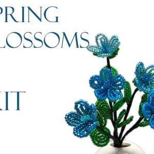 May include: A beaded flower arrangement in a white vase. The flowers are blue and green and are arranged in a bouquet. The text "SPRING BLOSSOMS KIT" is visible in the image.