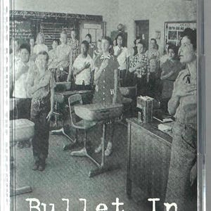 May include: A cassette tape case featuring the band name "rage against the machine" above the album title "Bullet In The Head". The cover art is a black and white photo of a classroom with students.