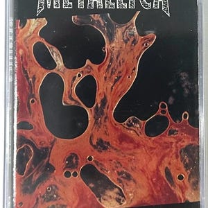 May include: Metallica "Load" cassette tape. The cassette case features a black background with a red and orange abstract design. The word "METALLICA" is at the top, and "LOAD" is at the bottom, both in a silver, textured font.