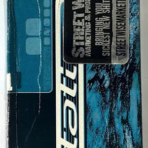 May include: A dark blue and white product package with the word "statt" in large white letters. A black sticker with the text "STREET WISE MARKETING & PROMOTION" and "BRINGING YOU THE SICKEST NEW SHIT FIRST!" is affixed to the package. The website streetwisemarketing.com is also visible.