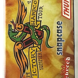 May include: A rectangular box with a stylized green snake design, the text "1998 Hardcore Tour" and "Victory Summer" in gold banners. The word "Thumb" is in a red box. The word "Snapcase" is in blue.
