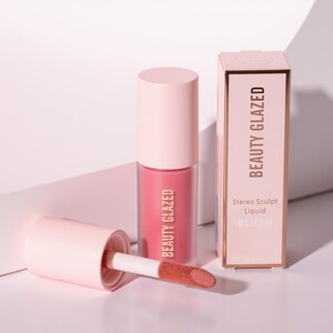 May include: A pink liquid blush product with a matching box. The blush is in a clear tube with a pink cap and a doe-foot applicator. The box and tube are labeled "BEAUTY GLAZED". The box also says "Stereo Sculpt Liquid BLUSH".