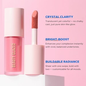 May include: A pink lip gloss tube and applicator with a coral-colored applicator tip. The text on the tube reads "BEAUTY GLAZED". The background is a light pink with text describing the product's features: Crystal Clarity, Bright-Boost, and Buildable Radiance.