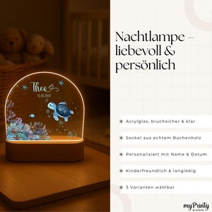 K&ouml;nnte beinhalten: Ein halbkreisf&ouml;rmiges Acryl-Nachtlicht mit einem Aufdruck von einer Meeresschildkr&ouml;te und Korallenriff, beleuchtet durch einen hellen Holzsockel. Der Text "Theo" und "16.05.2024" ist auf der Acrylfl&auml;che gedruckt. Rechts steht deutscher Text.