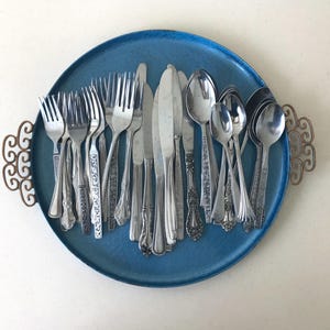 May include: A set of three ceramic mugs with a speckled, matte finish. The mugs are in shades of cream, light gray, and dark gray. Each mug has a simple, minimalist design and a rounded handle.