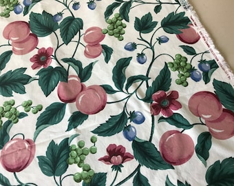 Pode incluir: Tecido branco com um padrão repetido de pêssegos cor-de-rosa, folhas verdes, uvas verdes e flores cor-de-rosa. O tecido tem uma borda franjada e o texto "The Gift...Southern Charm Collection Exclusive Et 8" impresso na borda.