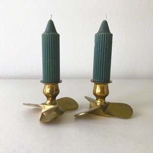 Puede incluir: Dos candelabros de lat&oacute;n con bases en forma de h&eacute;lice y velas de color verde oscuro.