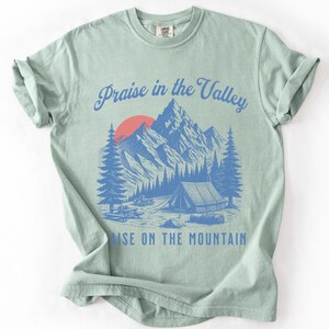 Elevation Brandon Lake Fan Shirt Praise in the Valley Praise on the Mountain Comfort Colors 1717 tee,tshirt in neutral colors trendy with praise in the valley in cursive font and praise on the mountain in a sans serif witha blue print of a mountain