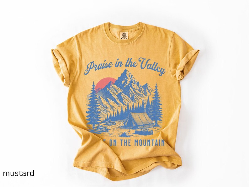 Elevation Brandon Lake Fan Shirt Praise in the Valley Praise on the Mountain Comfort Colors 1717 tee,tshirt in neutral colors trendy with praise in the valley in cursive font and praise on the mountain in a sans serif witha blue print of a mountain