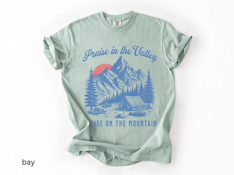 Elevation Brandon Lake Fan Shirt Praise in the Valley Praise on the Mountain Comfort Colors 1717 tee,tshirt in neutral colors trendy with praise in the valley in cursive font and praise on the mountain in a sans serif witha blue print of a mountain
