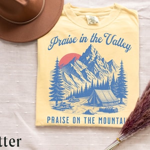 Elevation Brandon Lake Fan Shirt Praise in the Valley Praise on the Mountain Comfort Colors 1717 tee,tshirt in neutral colors trendy with praise in the valley in cursive font and praise on the mountain in a sans serif witha blue print of a mountain