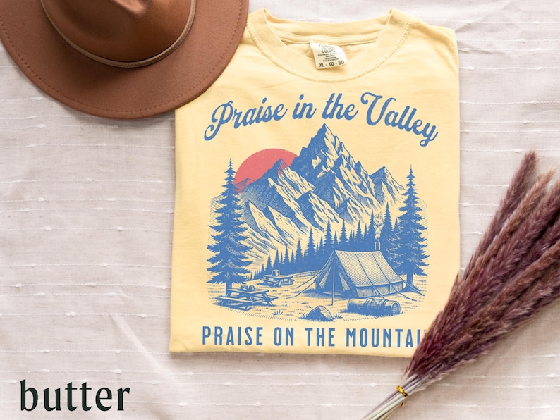 Elevation Brandon Lake Fan Shirt Praise in the Valley Praise on the Mountain Comfort Colors 1717 tee,tshirt in neutral colors trendy with praise in the valley in cursive font and praise on the mountain in a sans serif witha blue print of a mountain