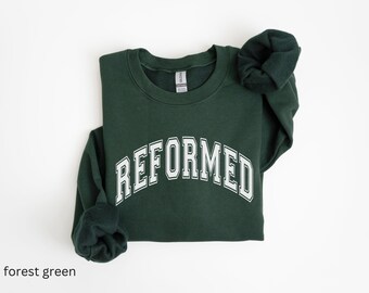 May include: A forest green sweatshirt with the word "REFORMED" printed in white on the front.
