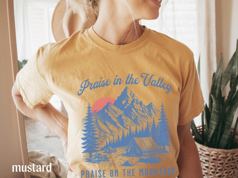 Elevation Brandon Lake Fan Shirt Praise in the Valley Praise on the Mountain Comfort Colors 1717 tee,tshirt in neutral colors trendy with praise in the valley in cursive font and praise on the mountain in a sans serif witha blue print of a mountain