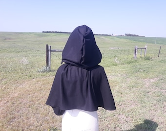 May include: A black hooded cape with a long, flowing design. The cape is made of a soft, comfortable fabric and is perfect for adding a touch of mystery and intrigue to any outfit.