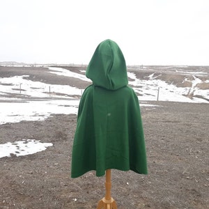 May include: A green hooded cape with a long, flowing design. The cape is made of a soft, comfortable fabric and is perfect for adding a touch of drama to any outfit.