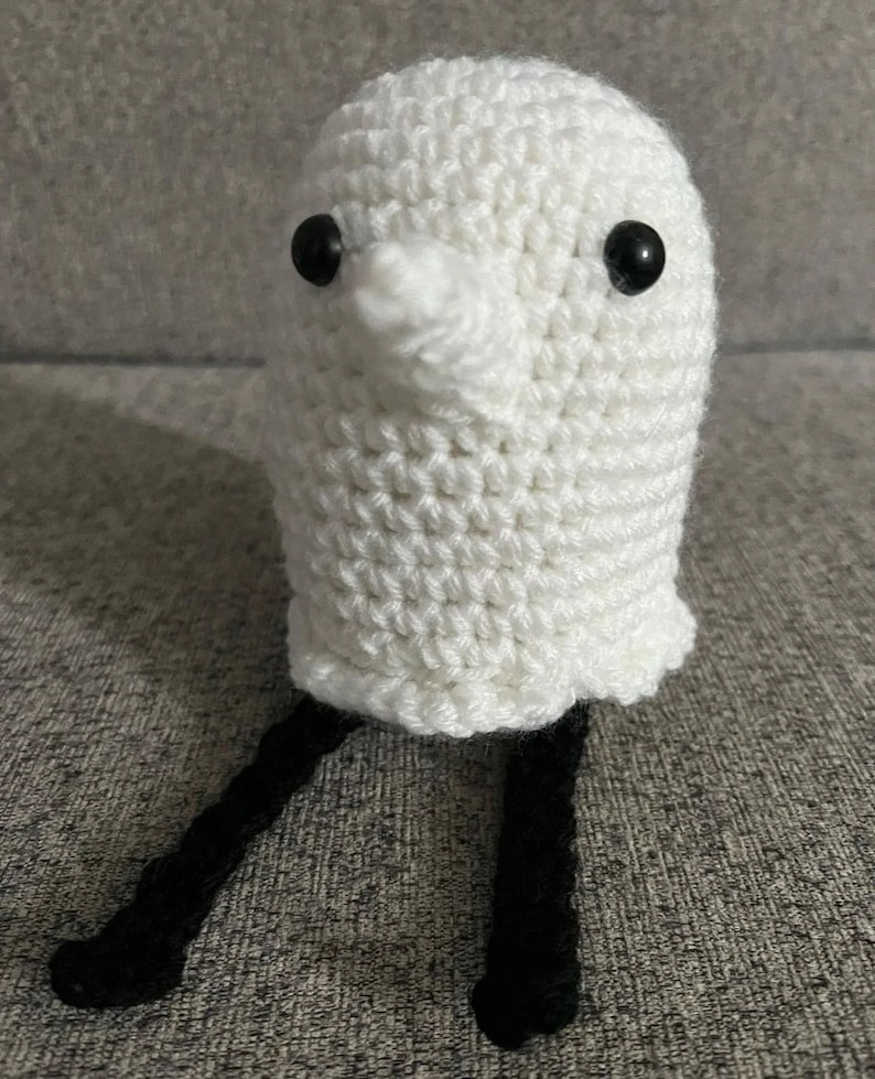 May include: White crocheted ghost with black yarn legs and black button eyes.