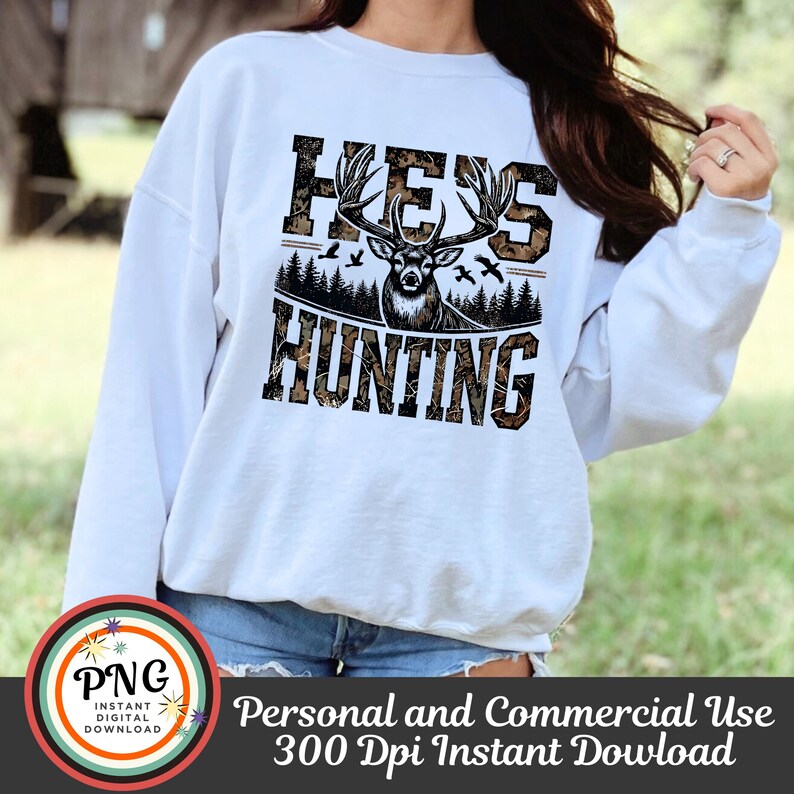 May include: White sweatshirt with a camouflage pattern and the text "Hey's Hunting" with a deer silhouette in the center.
