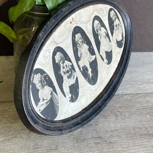 May include: A black oval frame with a white background and six black and white photos of children. The photos are arranged in a circle and each photo has a name written below it. The text "The Time Swings" is written in a circle around the photos.