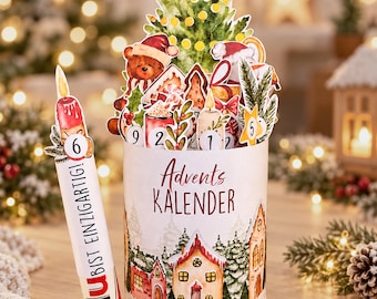 Könnte beinhalten: Ein zylindrischer Adventskalender mit einer Winterdorf-Illustration und dem Text Advents KALENDER. Ein kerzenförmiger Einsatz zeigt die Zahl 6 und den Text DU BIST EINZIGARTIG. Oben befinden sich Aquarell-Ausschnitte eines Weihnachtsbaums, eines Teddybären und nummerierter Weihnachtsmotive.