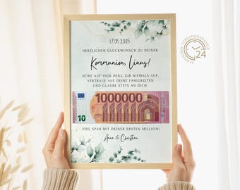 May include: A framed card with a watercolour background and green leaves. The card has a message congratulating someone on their communion, with the text "17.05.2025", "Herzlichen Glückwunsch zu deiner Kommunion, Linus!" and "Hore auf dein Herz, gib niemals auf, vertraue auf deine Fähigkeiten und glaube stets an dich." The card also has a picture of a 10 euro bill with the text "1000000" and "Viel Spaß mit deiner ersten Million!" and "Anna & Christian".