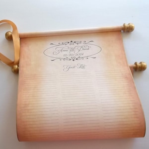 May include: A vintage-style scroll with a gold ribbon and wooden dowels. The scroll is decorated with a calligraphic design and the text "Anna & David 12/20/2024 Guest List".